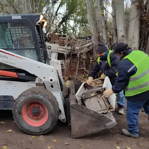Maquinaria bobcat cargando escombros
